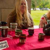 Students work a booth displaying handmade pottery at Student Small Business Market.